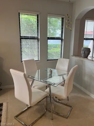 Dining area featuring plenty of natural light, light tile patterned floors, and arched walkways