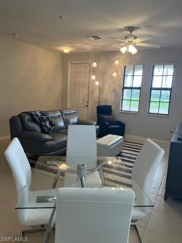 Living room featuring ceiling fan and light tile flooring