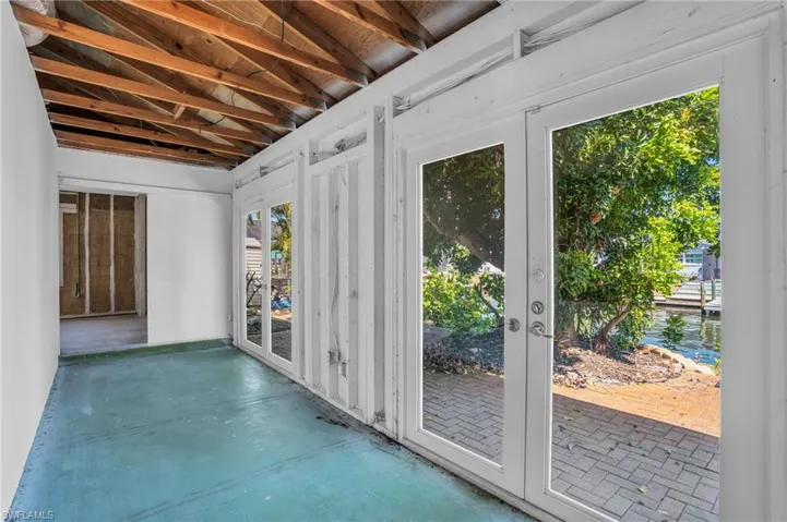 Unfurnished sunroom featuring french doors and lofted ceiling