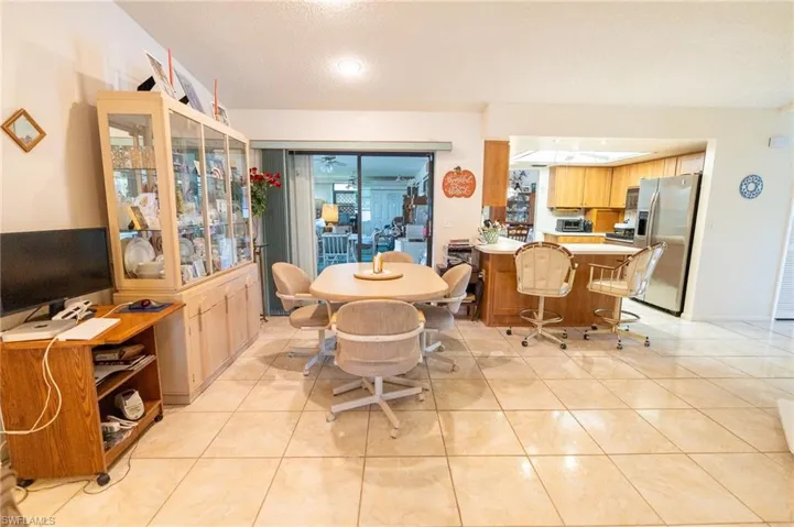 Dining space with sliders to lanai featuring light tile patterned flooring