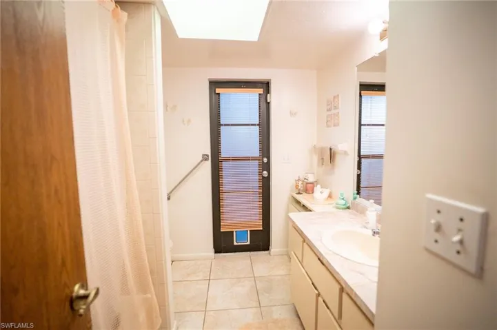 Full bathroom with tile patterned flooring, vanity, and curtained shower