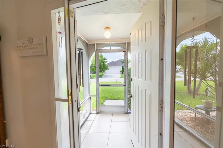 Doorway featuring light tile patterned flooring