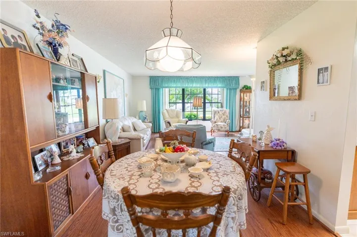 Dining room featuring a textured ceiling, light wood-style floors, and a chandelier
