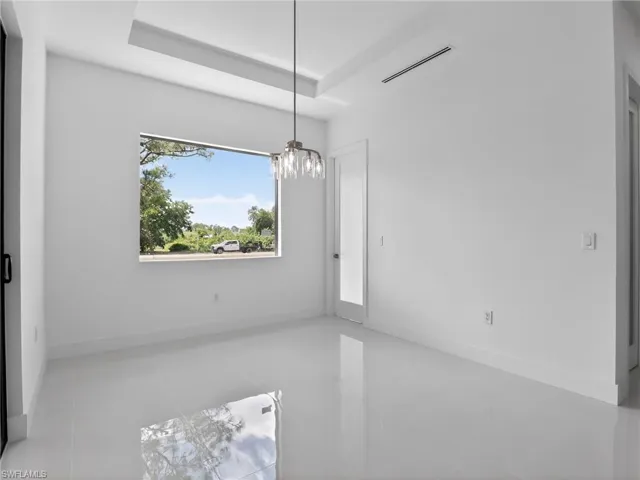 Room with white walls, a large window, and a modern light fixture