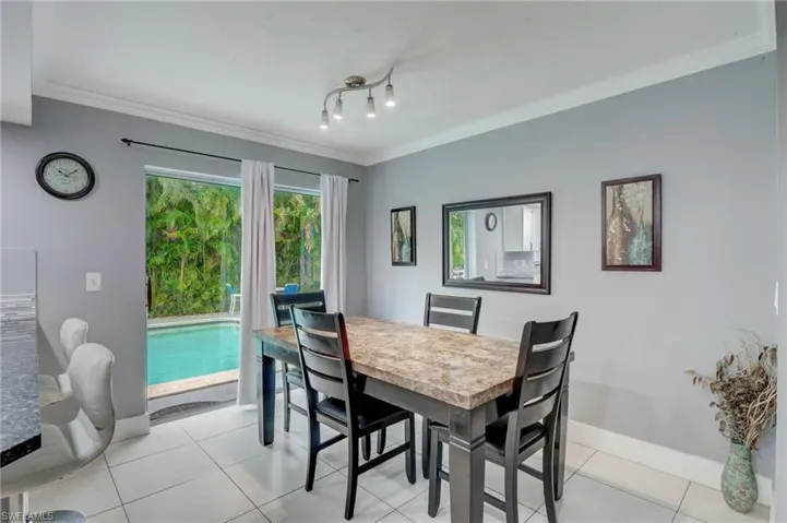 Tiled dining room with crown molding and rail lighting
