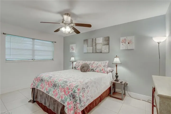 Tiled bedroom featuring ceiling fan