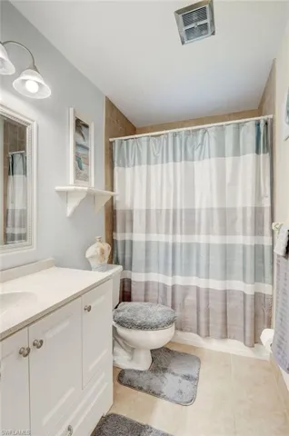 Bathroom featuring tile floors, vanity, and toilet