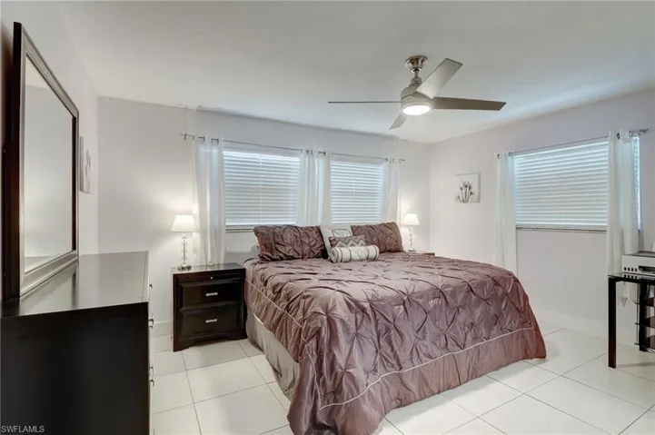 Bedroom with light tile flooring and ceiling fan
