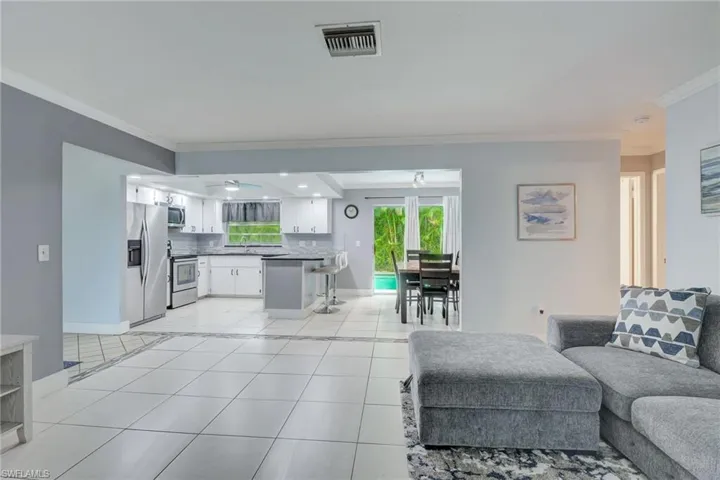 Tiled living room with sink and ornamental molding