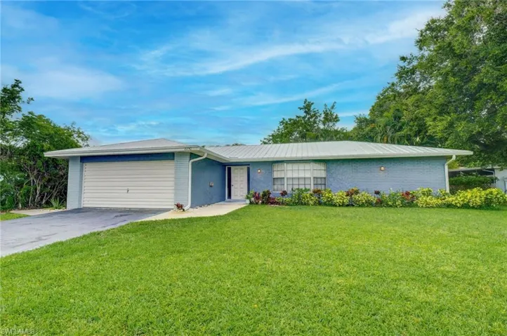 Ranch-style house with a garage and a front yard
