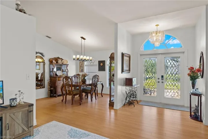 Entrance foyer featuring a chandelier, light wood-type flooring, and french doors