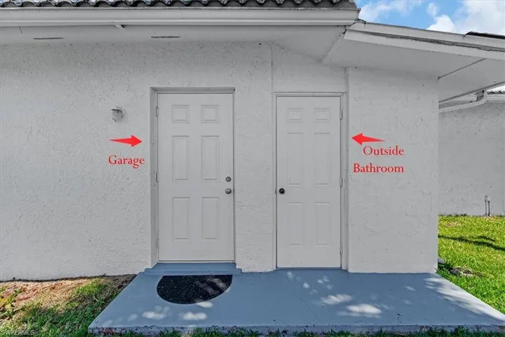 Man door to garage and exterior bathroom door