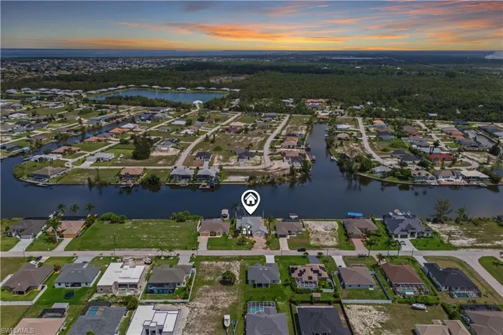 Warm sunset hues reflect off the water, highlighting the peaceful atmosphere and tropical charm of this Gulf-access neighborhood.
