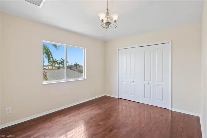 Charming guest bedroom with large windows that fill the room with natural light, creating a warm and welcoming atmosphere.
