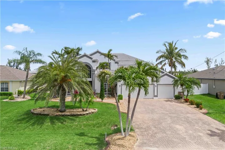The manicured lawn and inviting entryway create strong curb appeal in a quiet Cape Coral neighborhood.