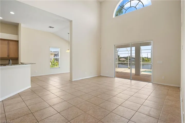 Spacious living room filled with natural light streaming through numerous large windows, creating an open and inviting atmosphere that connects indoor comfort with the outdoors.