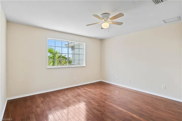 Inviting guest bedroom with an adjoining door to a bonus room, ideal for storage, hobbies, or extra living space.