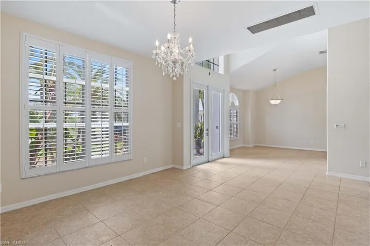 An elegant entryway with soaring ceilings, tile flooring, and a sweeping staircase that sets the tone for the home's sophisticated design.