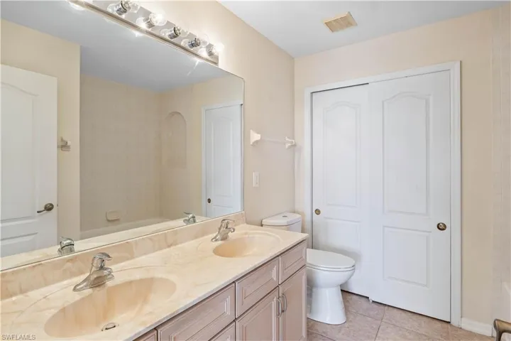 Bright guest bathroom with dual sinks and generous counter space, perfect for accommodating family and guests with ease.