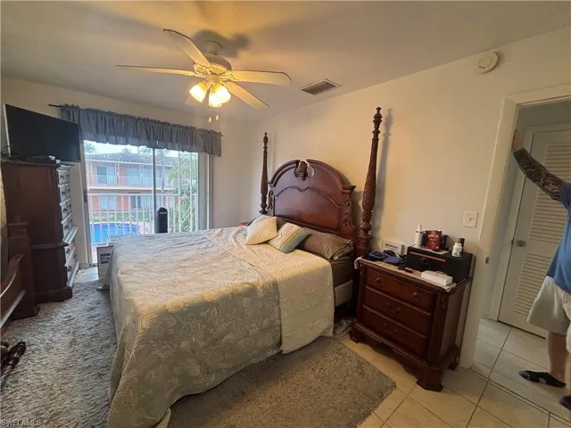 Bedroom with light tile patterned floors, a ceiling fan, and access to exterior