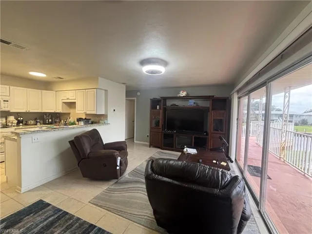 Living area featuring light tile patterned flooring and baseboards