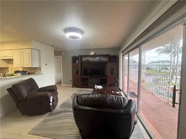 Living area with light tile patterned flooring and baseboards