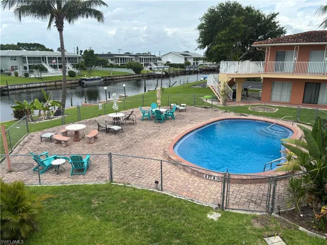 Community pool with a water view and a patio area