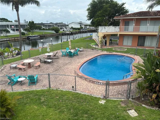 Community pool featuring a water view and a patio area