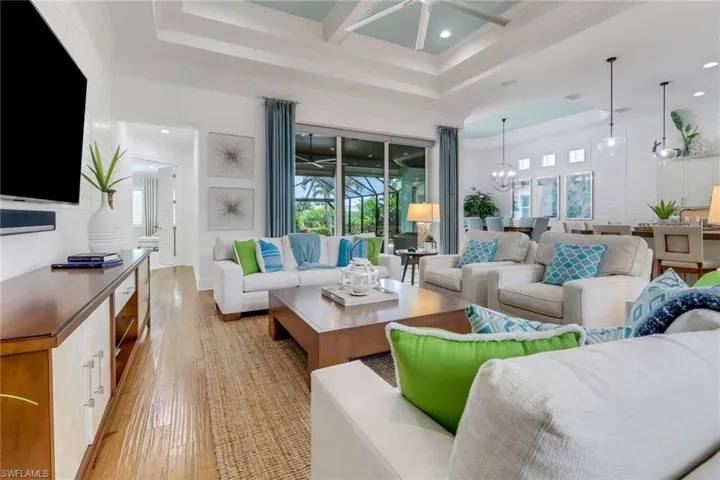 The grand living room with upscale furnishings and dramatically high ceiling with crown moulding give the entire great room a comfortable feel.