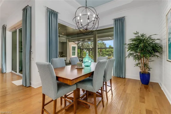 The dining room is adjacent to the kitchen and overlooks the covered lanai and screened pool and pool deck.