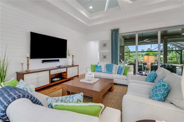 The living room is adjacent to the covered lanai, separated only by impact glass sliders which open to the lanai.