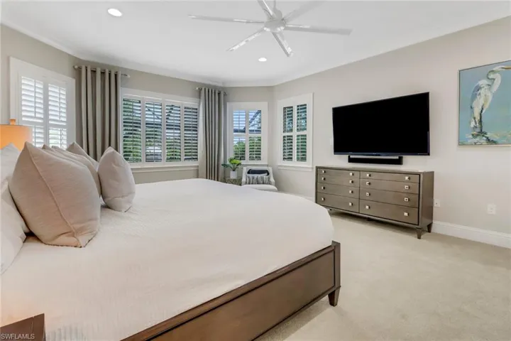 The furnished primary bedroom and custom draperies.