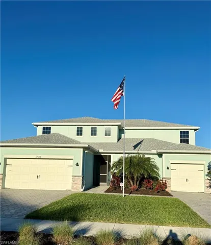 View of front of house with a garage and a front lawn