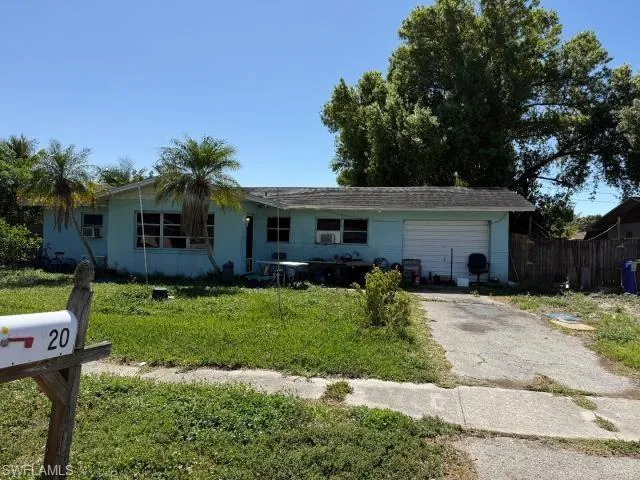 Ranch-style house with a garage, fence, a front yard, and aphalt driveway