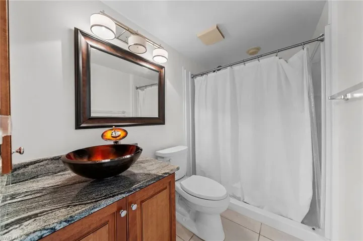 Bathroom with light tile patterned flooring, vanity, and a shower stall