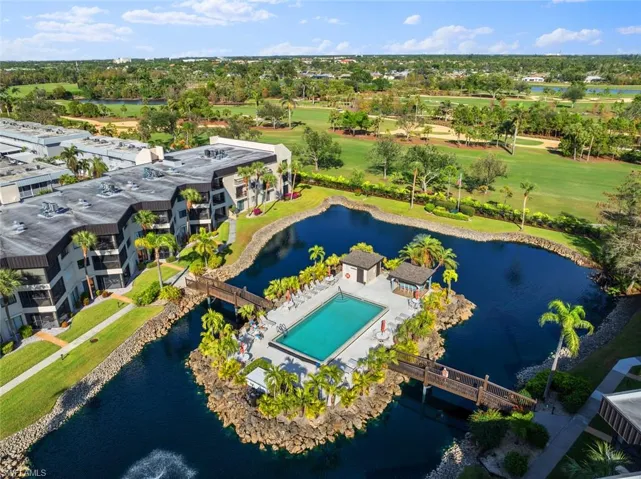 Drone / aerial view of a pool and a nearby body of water