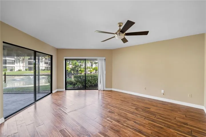 Empty room with dark wood-type flooring and a ceiling fan