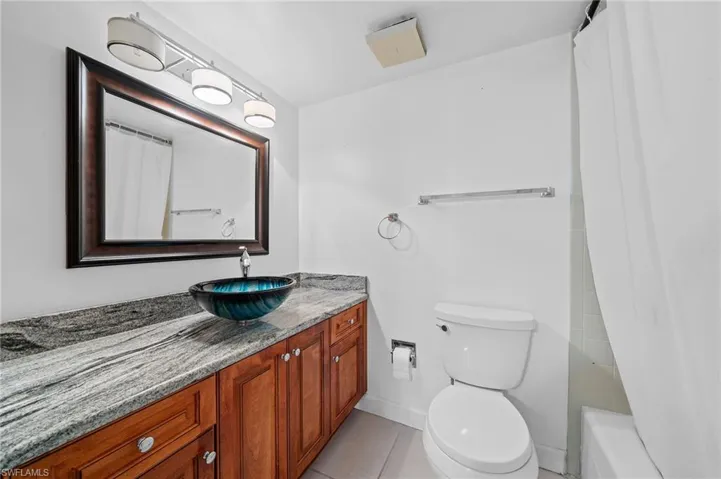 Bathroom with vanity, light tile patterned floors, and shower / tub combo