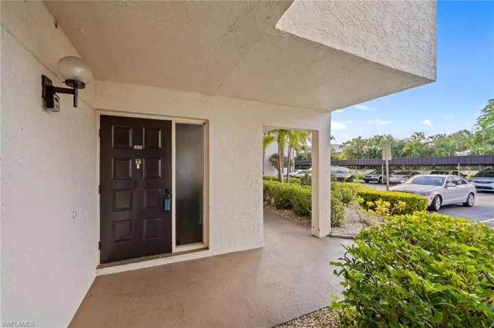 Entrance to property featuring stucco siding and covered porch