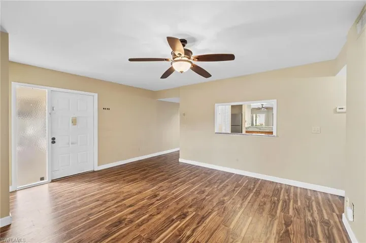 Unfurnished room with dark wood finished floors and a ceiling fan