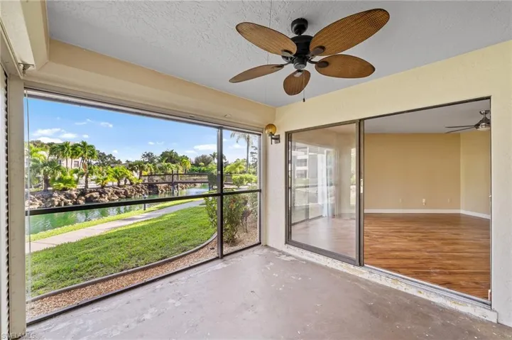Unfurnished sunroom featuring a water view and a ceiling fan