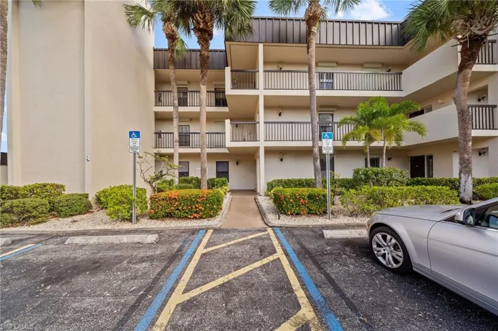 View of apartment building / complex featuring uncovered parking