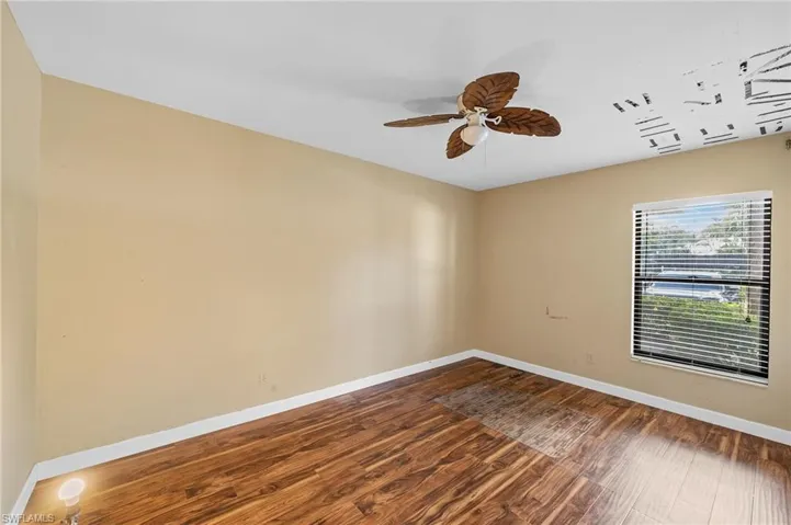 Spare room featuring dark wood-type flooring and a ceiling fan