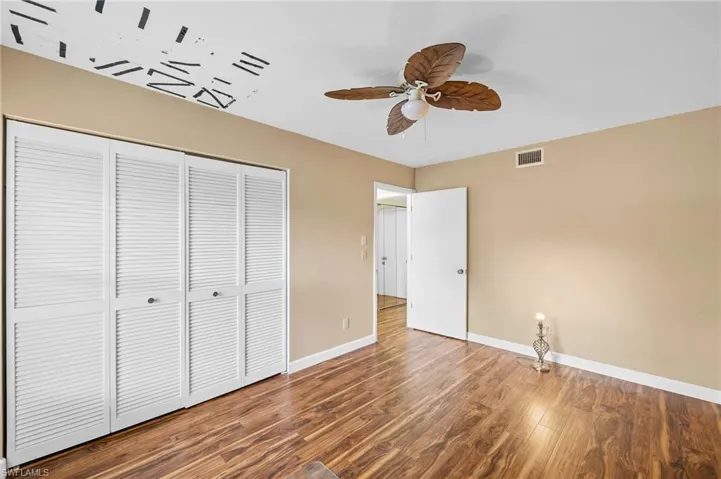 Unfurnished bedroom featuring wood finished floors, a closet, and ceiling fan