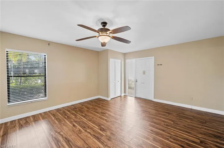 Spare room with dark wood-style flooring and a ceiling fan