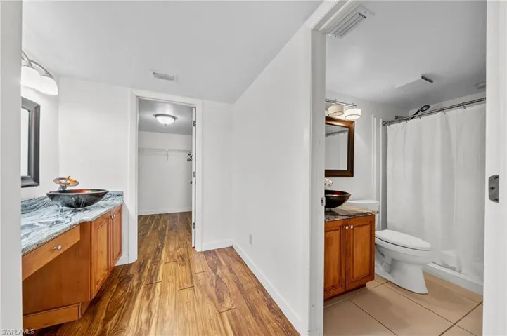Bathroom featuring vanity, a shower stall, light wood-style floors, and a walk in closet