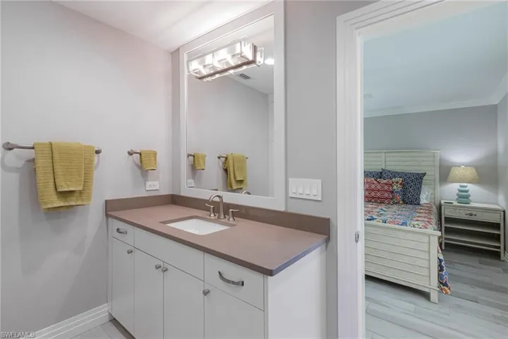 Bathroom with ornamental molding, vanity, and hardwood / wood-style floors