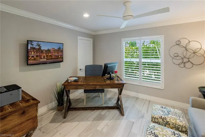 Office area with ceiling fan, light hardwood / wood-style flooring, and ornamental molding