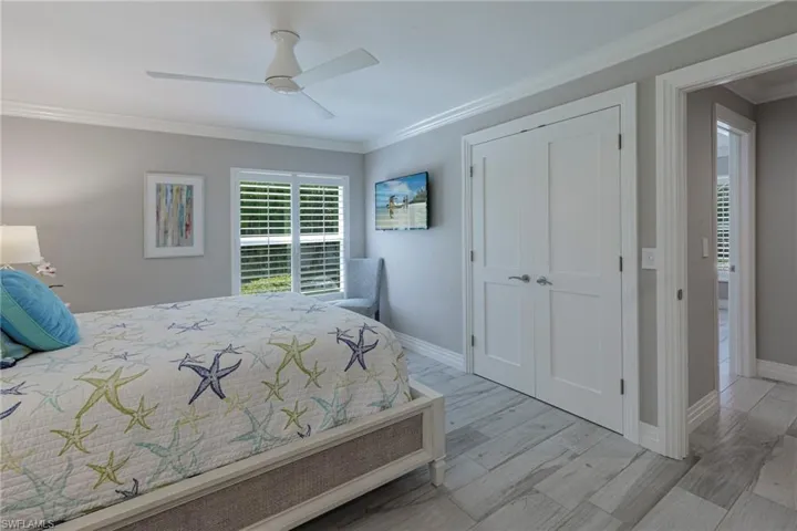 Bedroom featuring light hardwood / wood-style flooring, a closet, ceiling fan, and ornamental molding