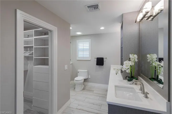 Bathroom featuring dual bowl vanity and toilet